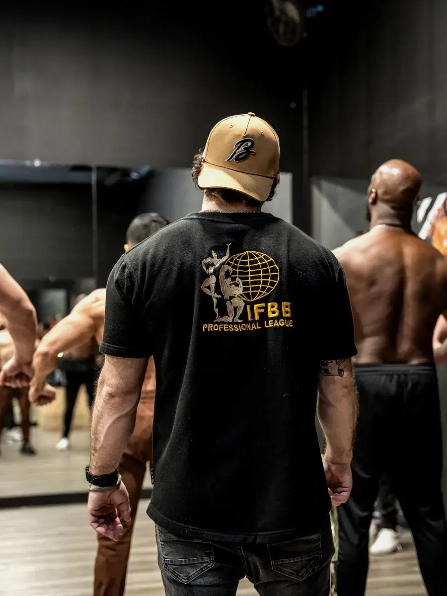 Coach Steven Kushnir teaching posing in IFBB Pro shirt