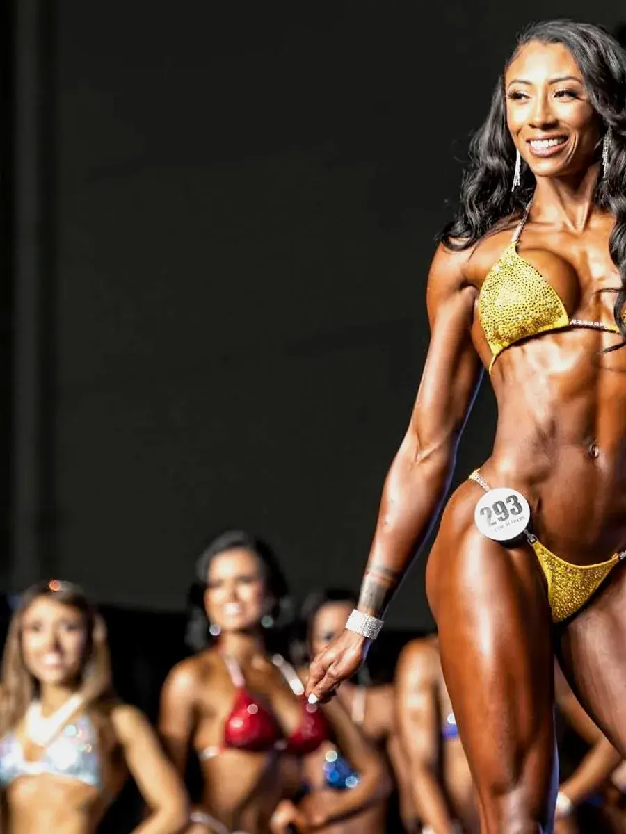 Bikini athlete in gold suit on stage